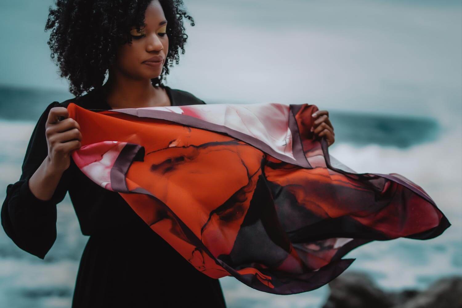 Woman with red silk scarf on the beach